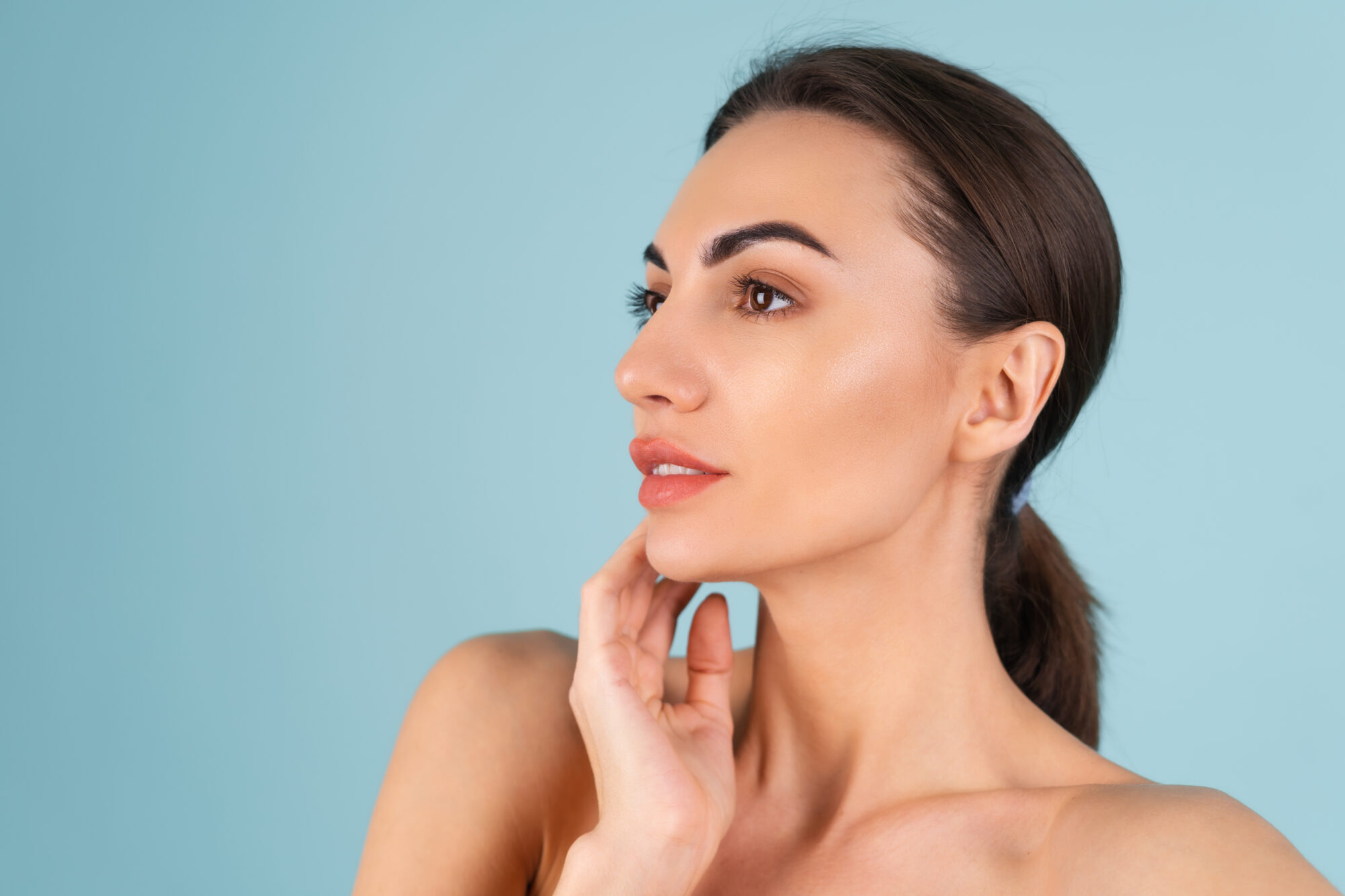 Close beauty portrait of a topless woman with perfect skin and natural make-up, plump nude lips, on a blue background Epilation laser definitive du menton Clinique Rivoli Massena 2