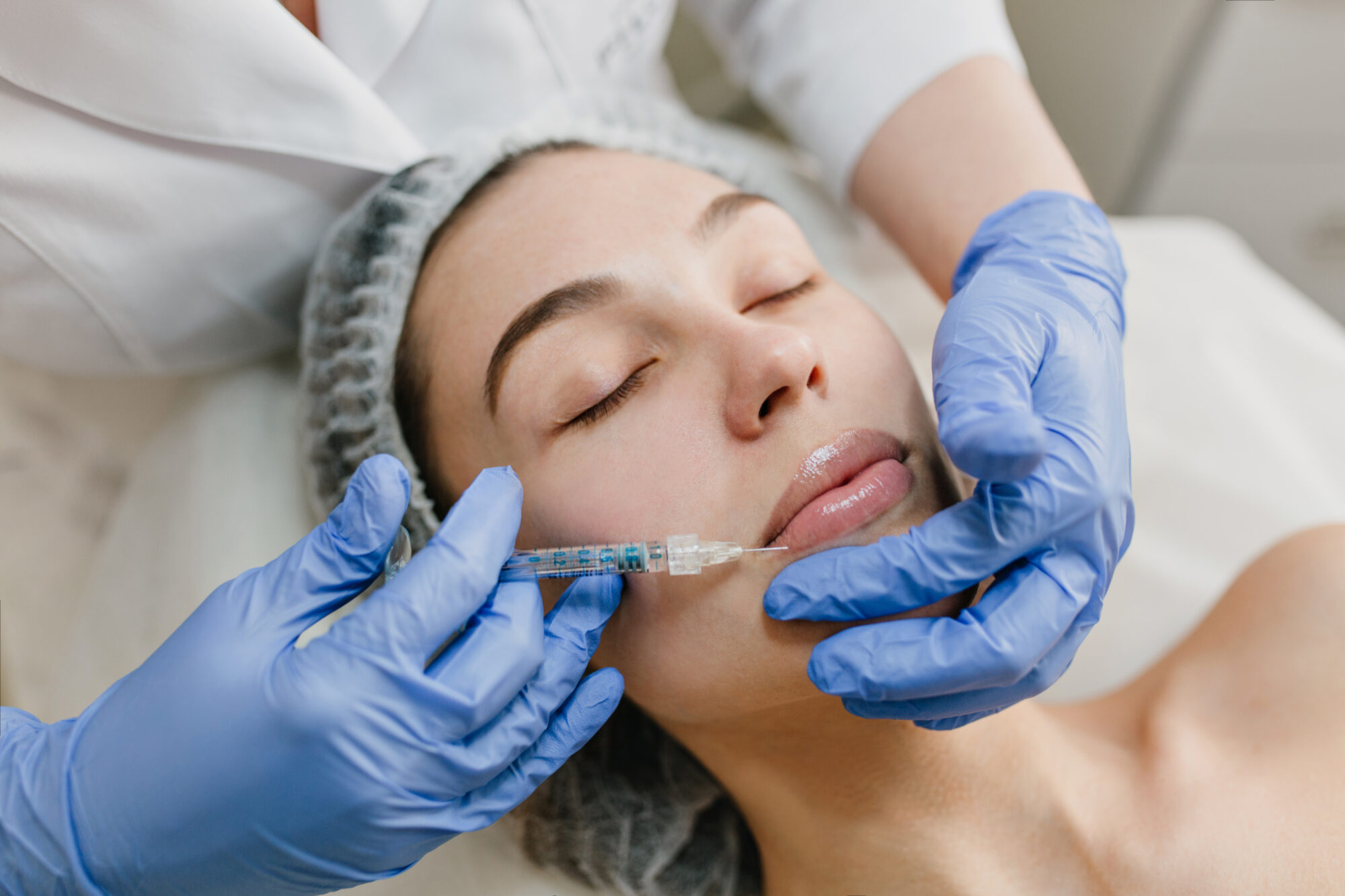Closeup portrait of beautiful woman during cosmetology therapy in beauty salon. Botox, lips, injecting, professional procedures, lifting, rejuvenation, modern devices, healthcare. Injection Acide Hyaluronique Strasbourg